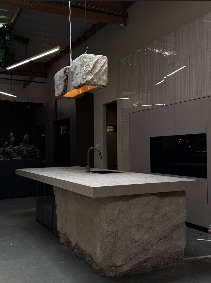 Sculpted stone kitchen island with suspended rock pendant light