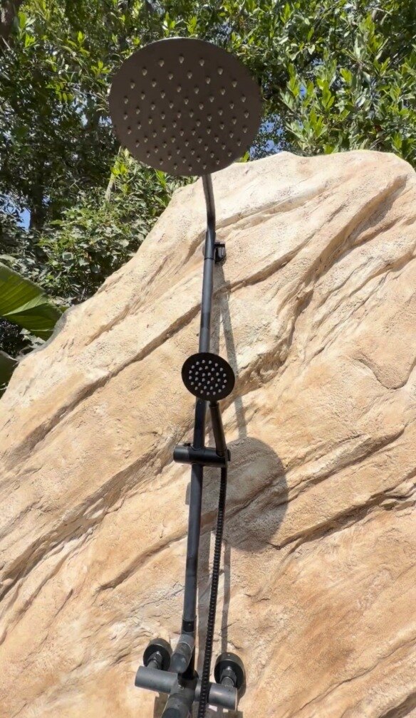 Detail of the rain head against hand-sculpted stone texture